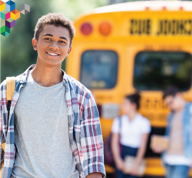 Teen standing in front of a bus