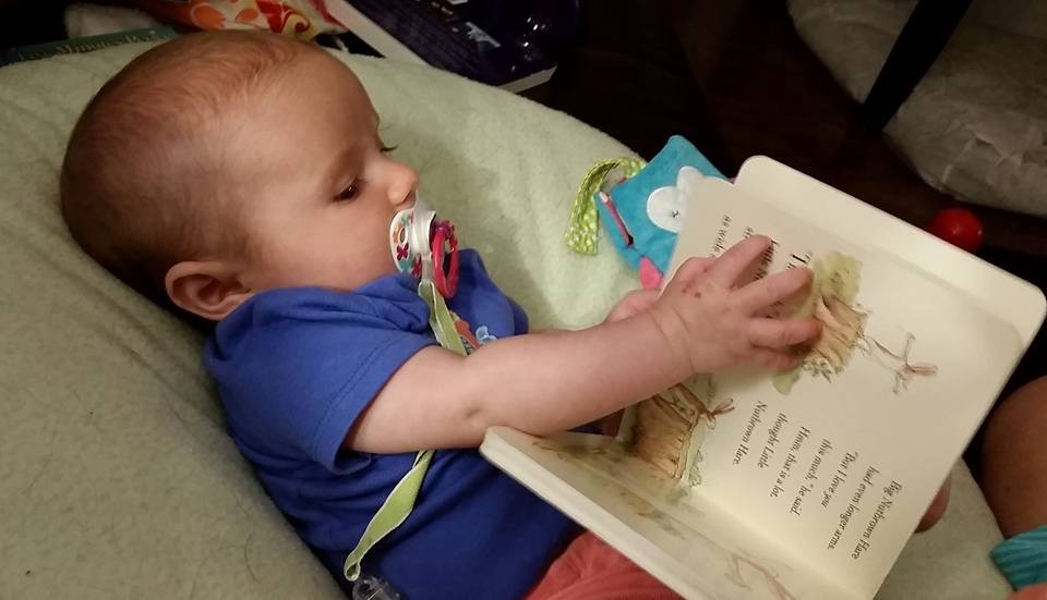 image of baby holding a book