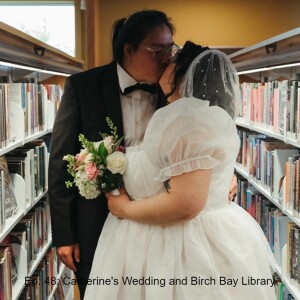 Bride and groom kissing in the library