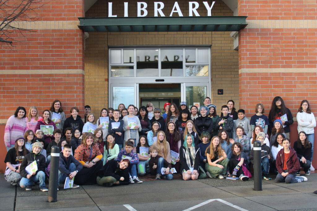 Teens posing in front of bus at Whatcomics reception at Lynden Library